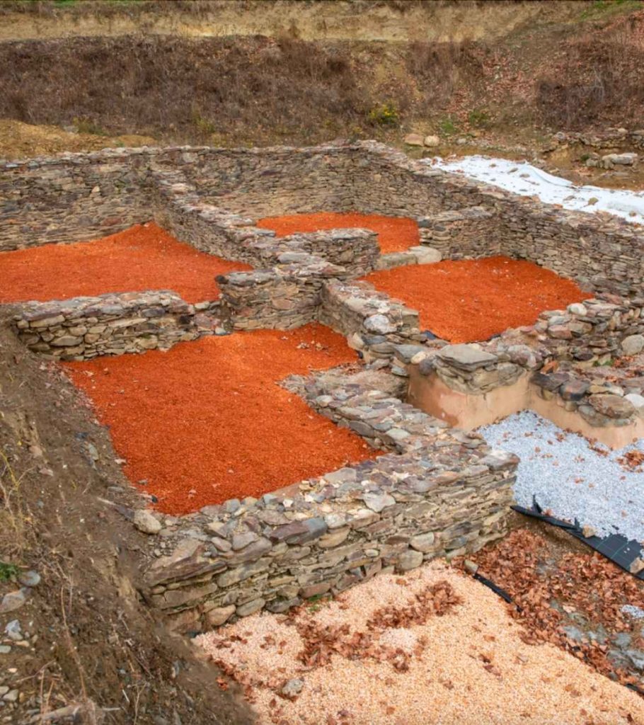 Restes arqueològiques del fòrum romà d'Iulia Libica, murs de pedra i estances delimitades amb grava de color