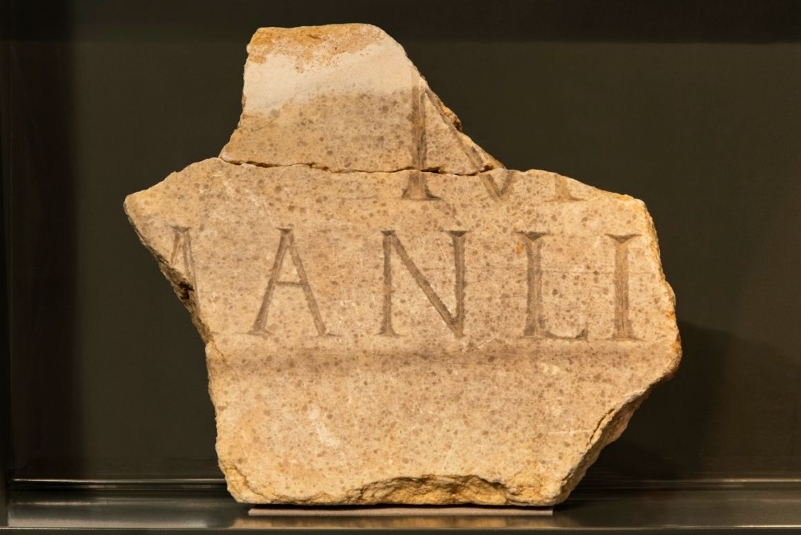 Fragment d'inscripció funerària romana en marbre amb el nom 'ANLI' del llinatge dels Manlia, trobat a Les Colomines, Llívia (finals segle I - primer terç segle II)