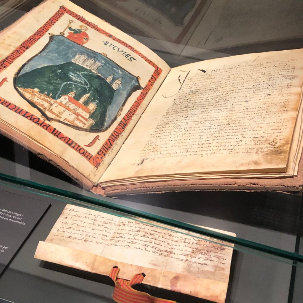 Llibre Ferrat obert amb escut il·luminat de Llívia i carta de poblament de Jaume I, 1257