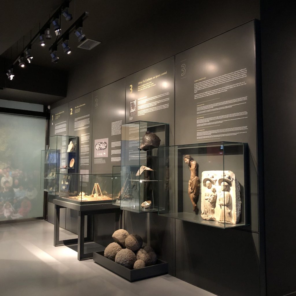 Vitrines de l'exposició de llarga durada amb talla romànica, pedres de trabuquet i restes arqueològiques de Llívia