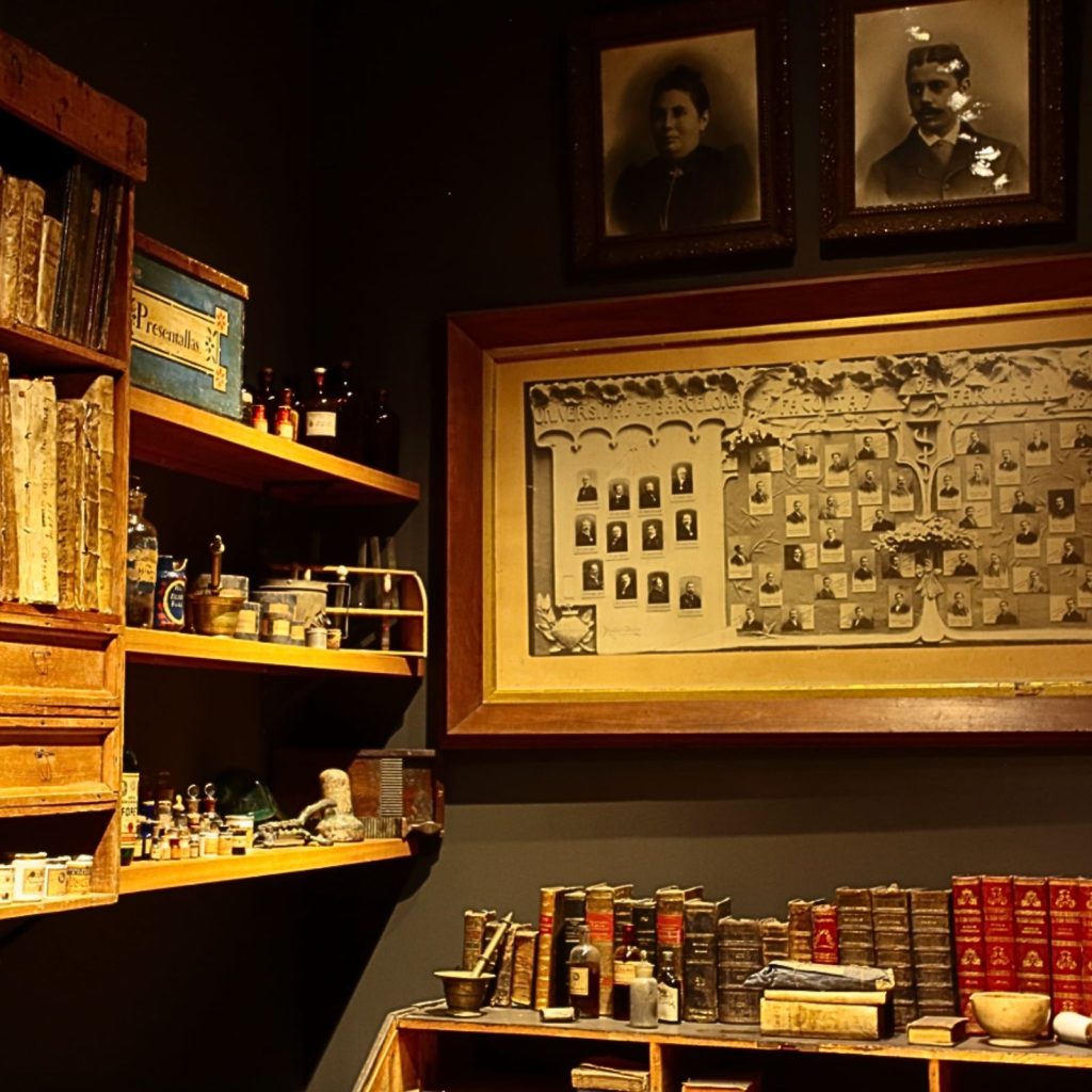 Rebotiga de la Farmàcia Esteva amb retrats familiars, arbre genealògic i llibres antics
