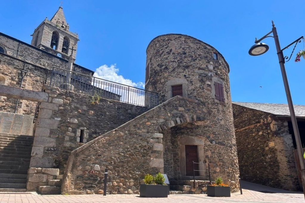Torre Bernat de So i l'església de Llívia, conjunt religiós i defensiu al cor del nucli històric.
